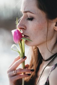 Young girl smelling a flower